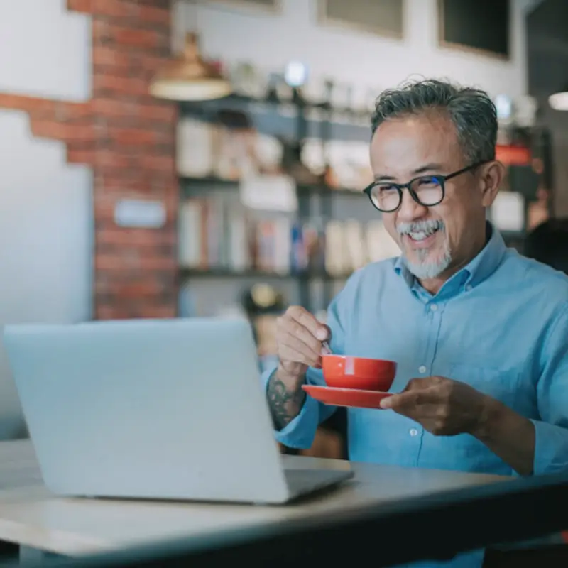 senior-man-in-coffee-shop-red-mug