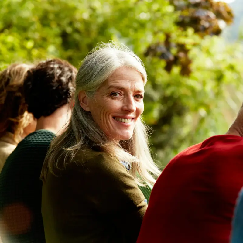 senior-woman-outdoors-looking-back-with-friends