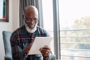 senior-man-smiling-tablet