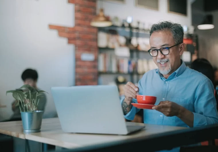 Medicare and Still Working Past 65 -senior-man-in-coffee-shop-red-mug